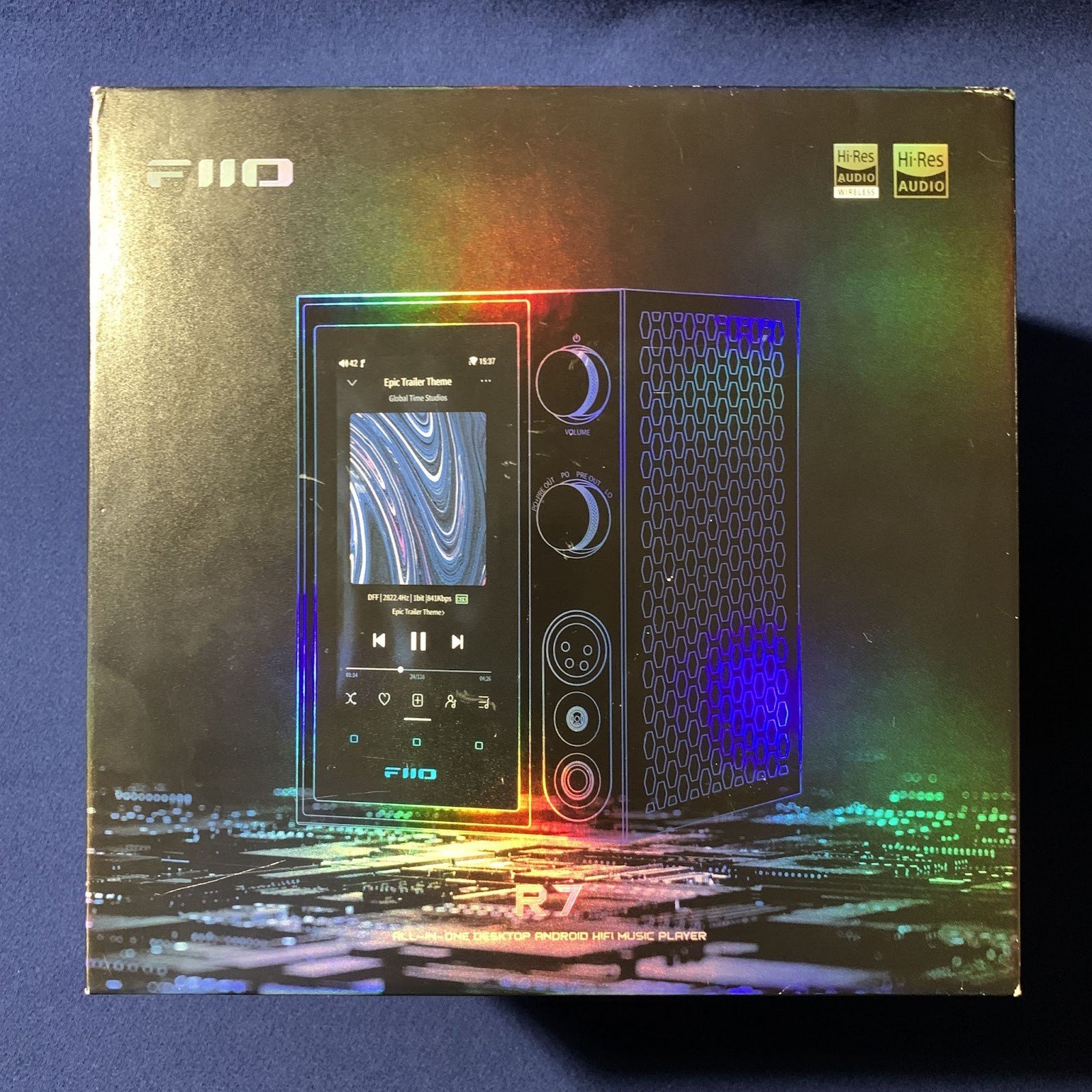 FiiO R7 comes in a sturdy cardboard box, shaped like a cube. Its design has a holographic effect - in bright light the surface shimmers with all the colors of the rainbow. 